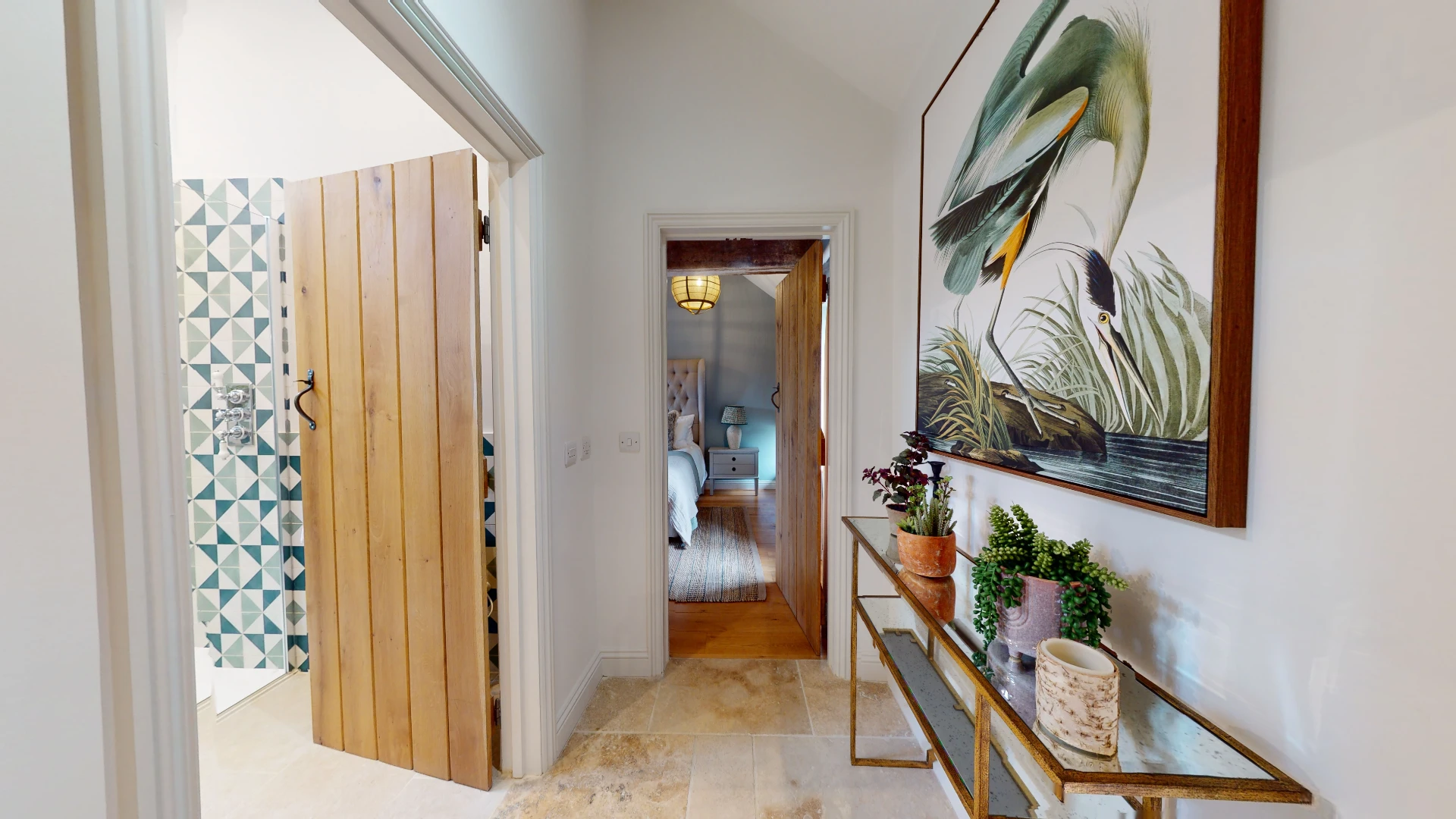 Stone Barn landing with patterned geometric tiling, an oak plank door and a console table