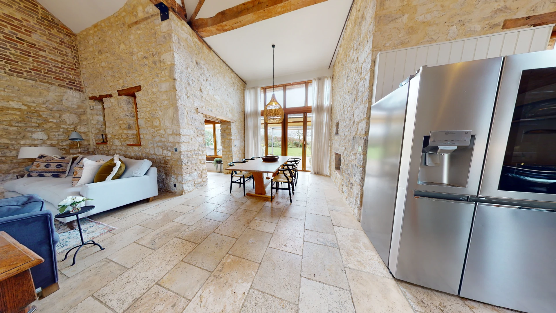 Stone Barn kitchen and dining space with a vaulted ceiling, exposed stone and an American-style fridge freezer